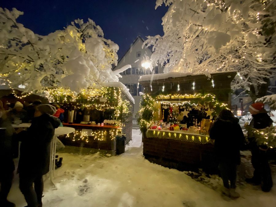 Verschneite Weihnachtshütten am Adventsmarkt in Wasserburg