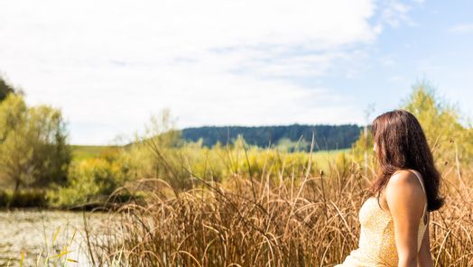 Eine Frau die auf einem Steg sitzt und die Aussicht genießt