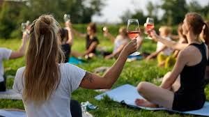 Eine Gruppe bei der Veranstaltung Yoga und Wein sitzend auf der Wiese beim Weingut Schmidt.