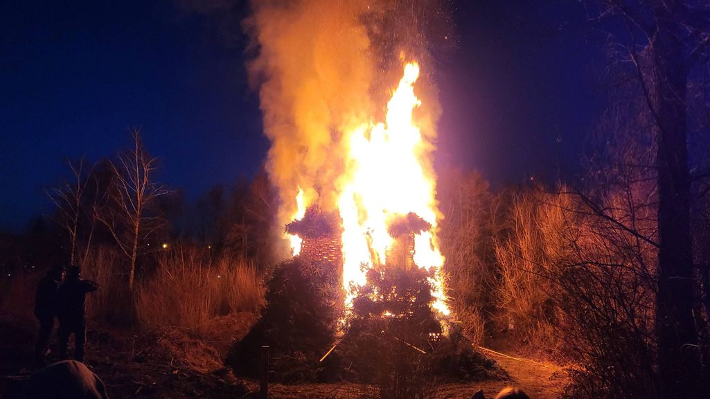 Funkenfeuer bei Nacht umgeben von Bäumen und Büschen im Birkenried in Wasserburg.