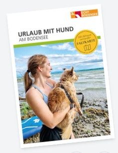 Titelbild Broschüre Urlaub mit Hund am Bodensee. Auf dem Titelbild ist eine Frau mit ihrem Hund am Bodenseeufer zu sehn.