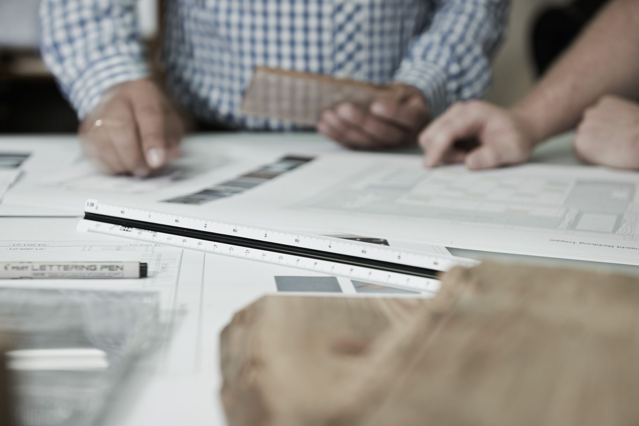 Mitarbeiter der Schreinerei bei der Konzeption eines neuen Projektes auf dem Papier.