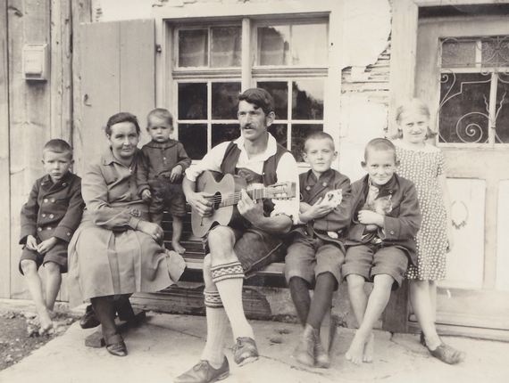 Max Freudig zupft auf seiner selbstgebauten Gitarre und spielt seiner Familie Musik vor.