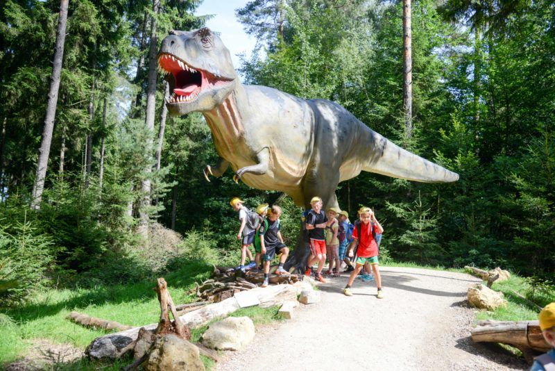 Lebensgroße Dinosaurier-Modelle im Außenbereich des Dinosaurier Museum Altmühltal, ein beliebtes Ausflugsziel in Bayern, für das Tickets verlost werden