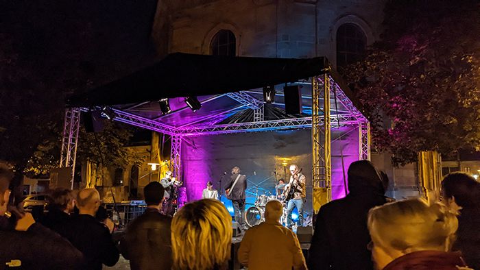 Künstler und Besucher beim Frei Bordsteinkante Festival in Erlangen, mit Straßenbühnen, Kunsthandwerk und Live-Musik.