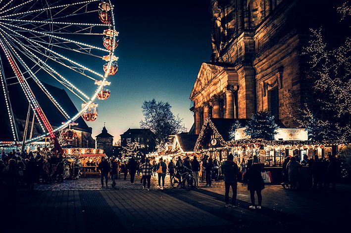 Beleuchtetes Riesenrad im Nürnberger Winterdorf bei Abenddämmerung.
