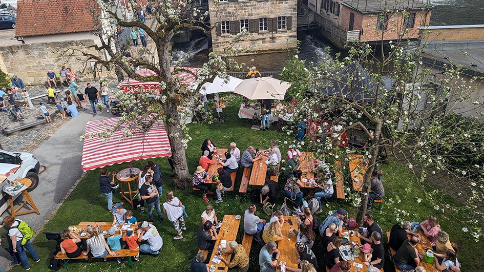 Besucher schlendern über den Regionalmarkt beim Event „Markt & Museum“ im Industriemuseum Lauf und erkunden Stände mit nachhaltigen Produkten und regionalen Köstlichkeiten.