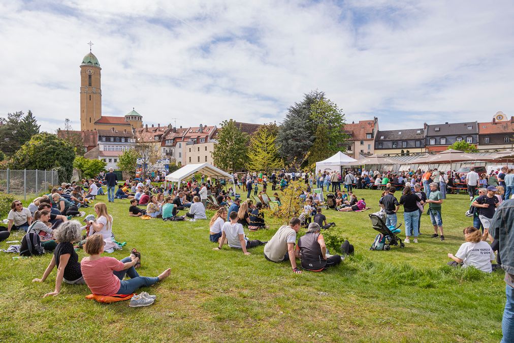 Menschen auf einer Wiese mit Blick auf die Gärtnerstadt Bamberg beim Tag der offenen Gärtnereien im Frühling