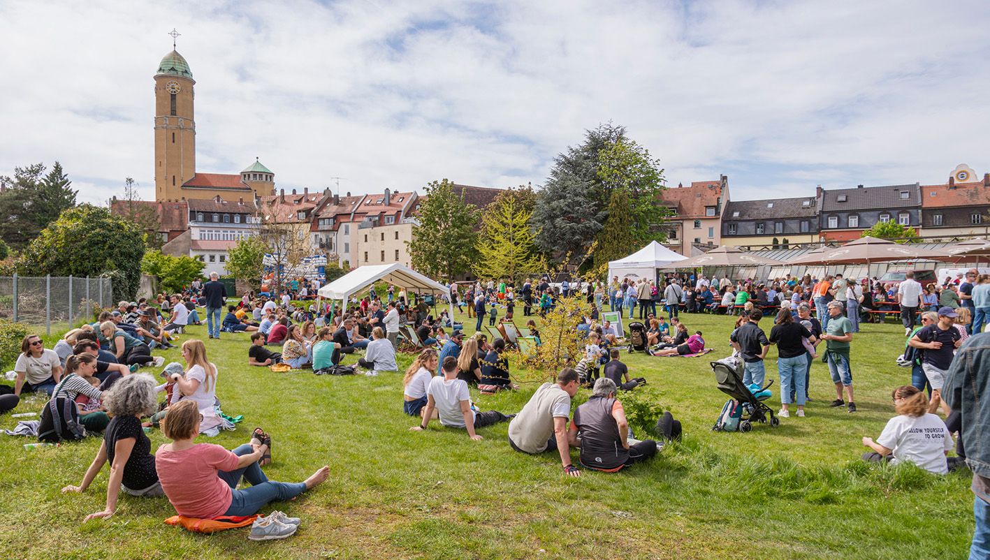 Besucher genießen den sonnigen Tag beim Tag der offenen Gärtnereien in Bamberg mit Blick auf die historische Gärtnerstadt.