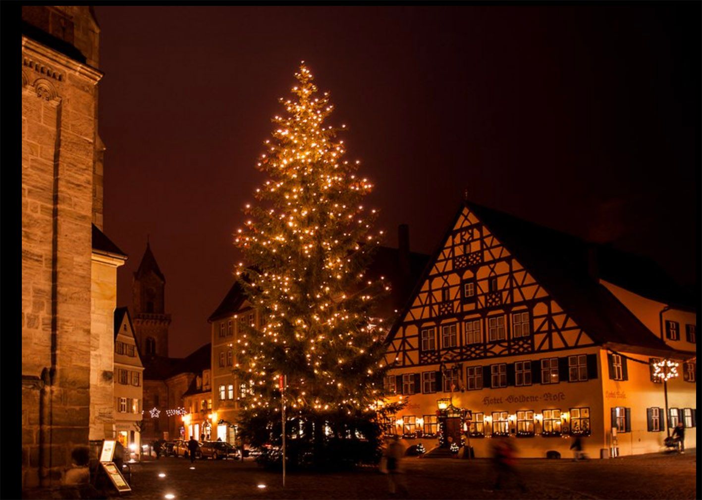 Großer, beleuchteter Weihnachtsbaum auf dem historischen Marktplatz von Dinkelsbühl, umgeben von Fachwerkhäusern und warmem Adventslicht.