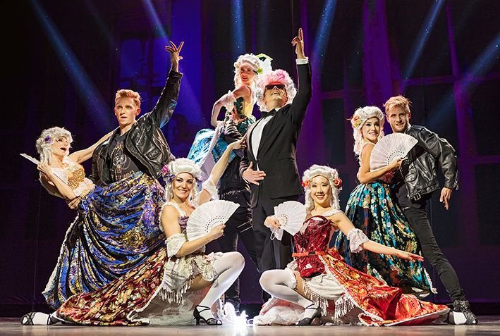 Ensemble des Musicals Falco meets Amadeus auf der Bühne mit Tanzszene und farbenprächtigen Kostümen.
