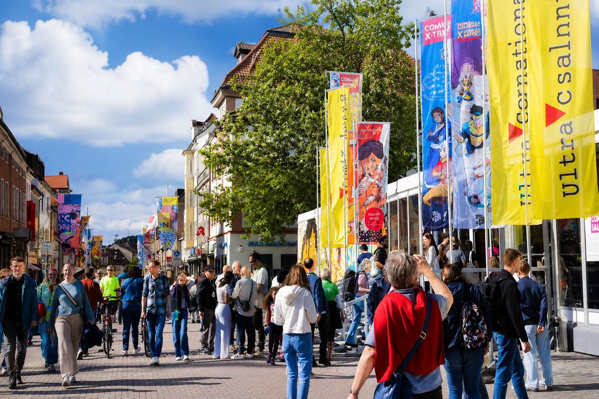 Comic Salon Erlangen 2026 mit tausenden Besuchern, bunten Comic Bannern, Cosplay und Festival Atmosphäre in der Erlanger Innenstadt