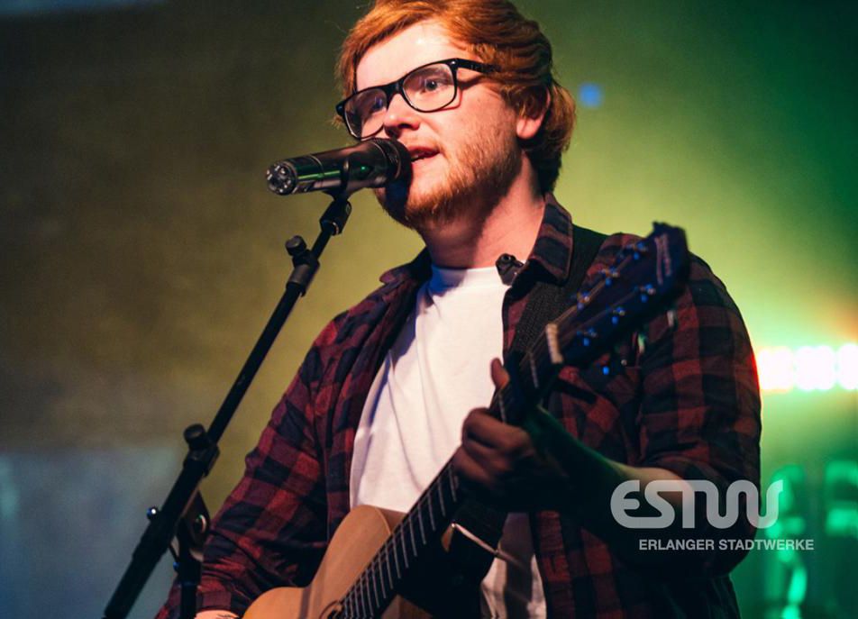 Sänger der Ed Sheeran Tribute Show bei einem Live-Auftritt mit Akustikgitarre vor dem Benefiz-Open-Air 2026 in Erlangen