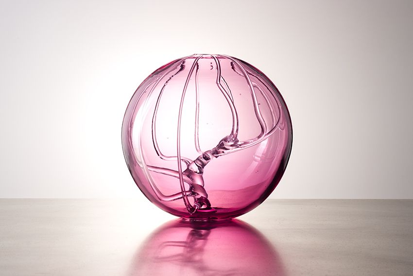 Pinkfarbenes, rundes Glasobjekt „Cerebral N° 72“ von Markus Marschmann mit geschwungenen inneren Strukturen.