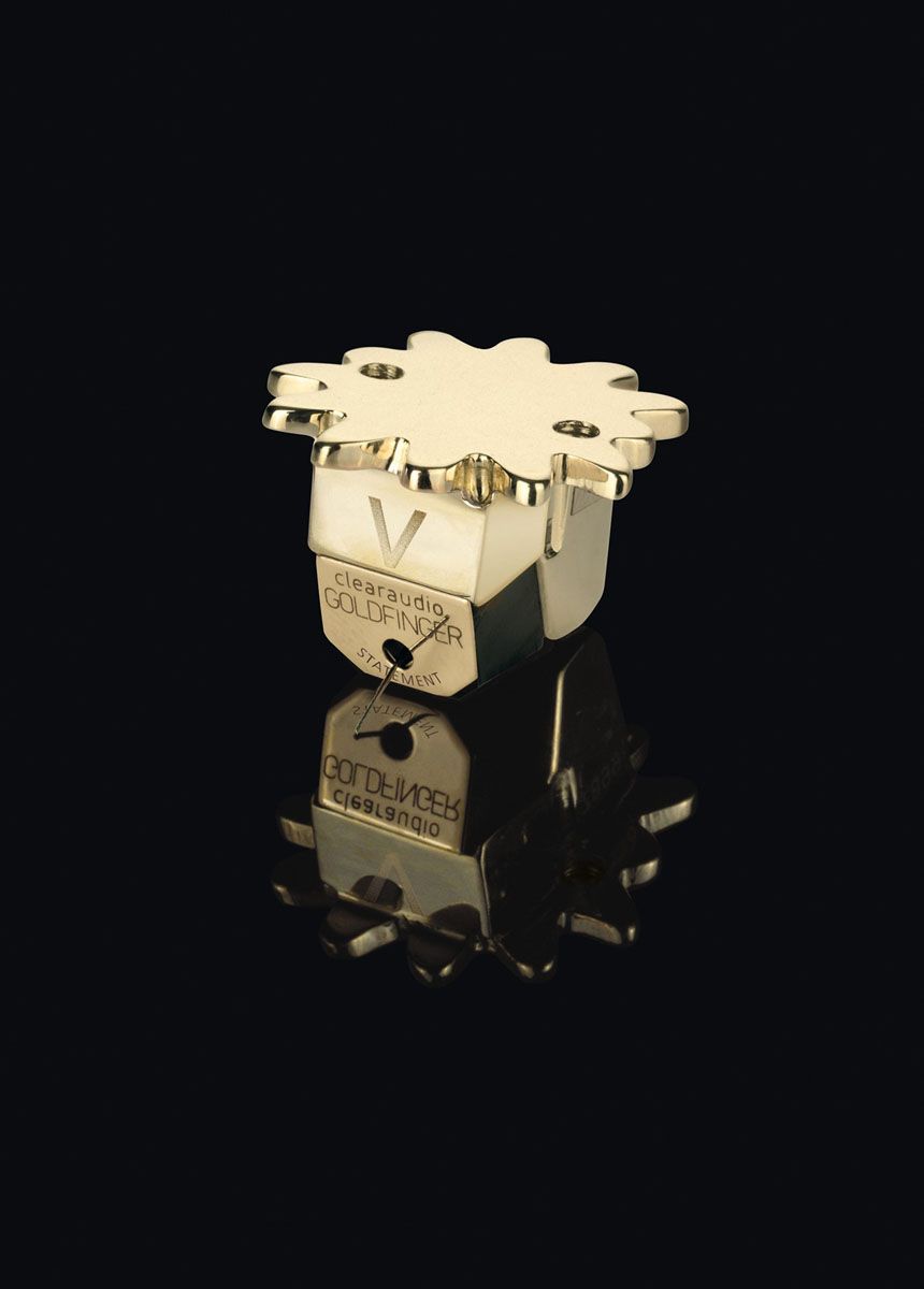 Studio photograph of the clearaudio Goldfinger Statement V2.1 MC cartridge made from solid 585 gold with the distinctive V engraving on a black, mirror-like background.