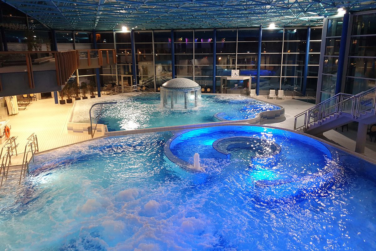 Beleuchtete Innenbecken der Spessart Therme am Abend