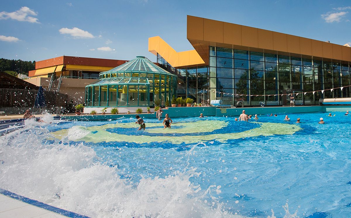 Hochspritzendes Wasser am Beckenrand des Wellen-Freibades
