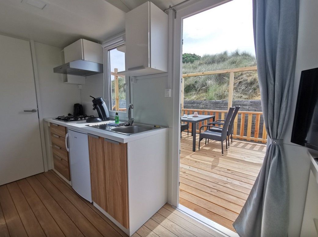 Küchenzeile und Terrasse eines kleinen Mobilheims auf dem Campingplatz Westerland