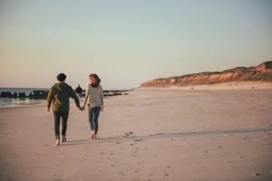 Paar spaziert am Strand vor dem Roten Kliff