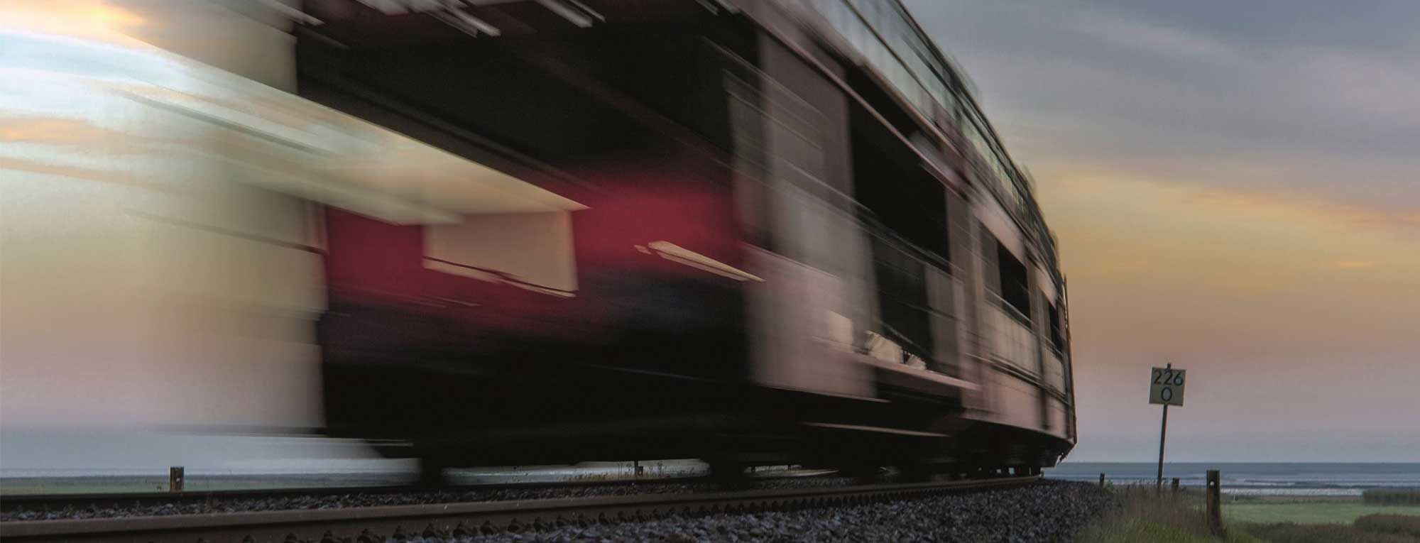 Verzerrte Aufnahme eines schnell fahrenden Sylt Shuttles auf dem Bahndamm zwischen Sylt und dem Festland