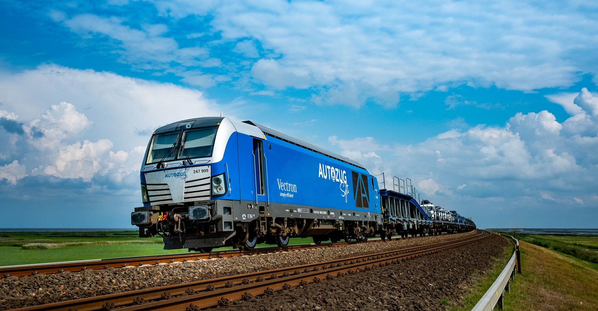 der blaue RDC Autozug auf dem Bahndamm zwischen dem Festland und Sylt