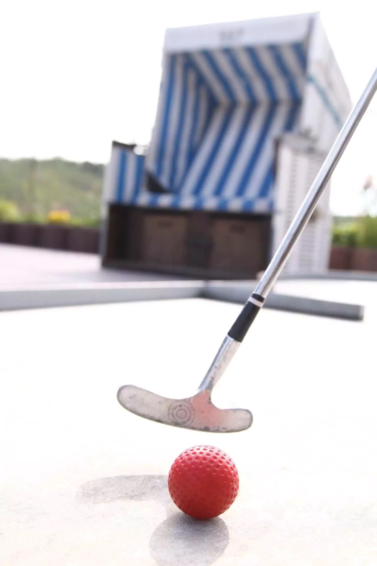 Minigolfschläger mit Strandkorb im Hintergrund