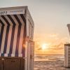 blau-weiß gestreifter Strandkorb am Westerländer oder Rantumer Strand bei Sonnenuntergang