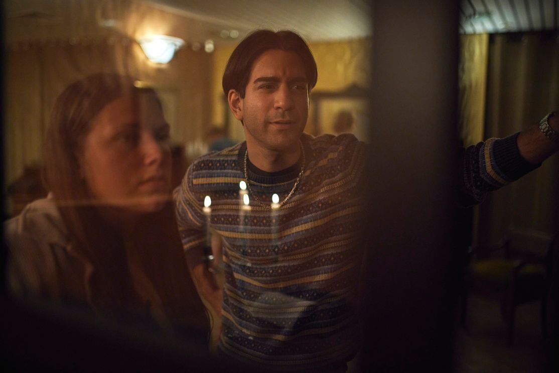 Eine junge braunhaarige Frau und ein junger schwarzhaariger Mann schauen rätselnd neben die Kamera