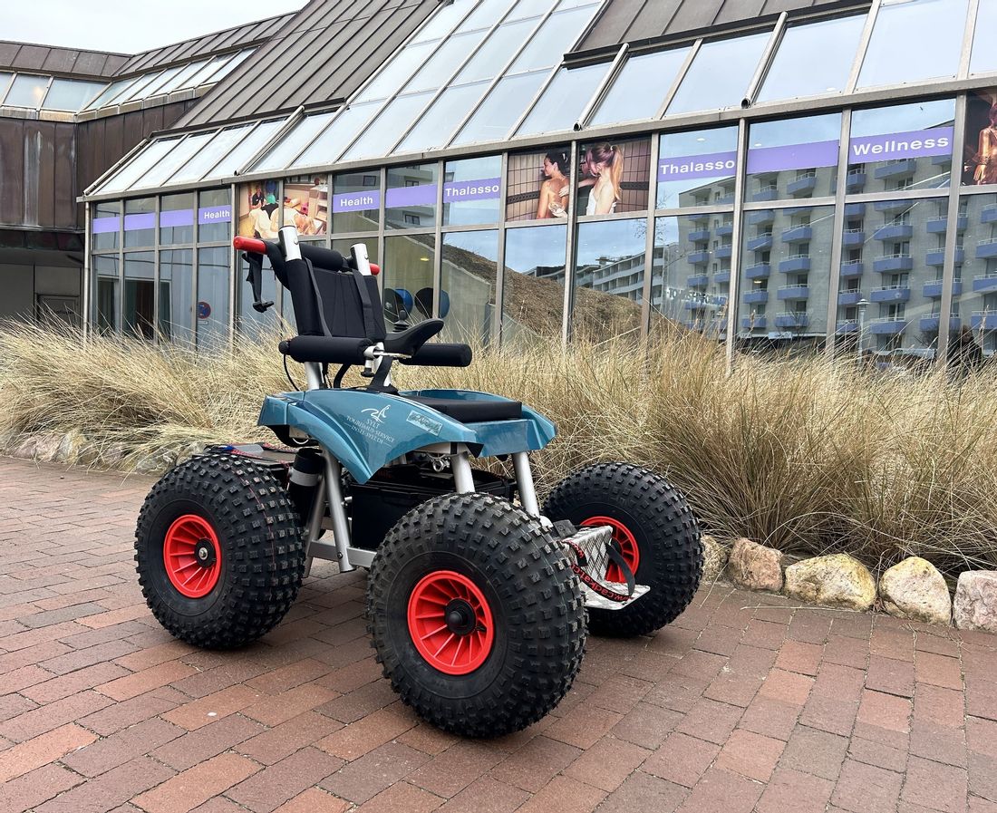 Elektrischer Strandrollstuhl für den Westerländer Strand steht vor dem Syltness Center