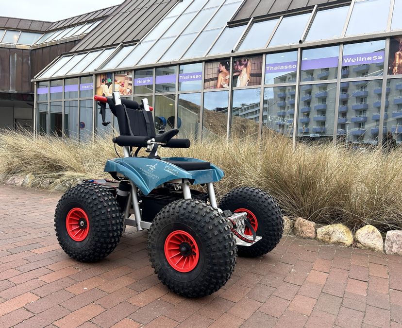 Elektrischer Strandrollstuhl für den Westerländer Strand steht vor dem Syltness Center