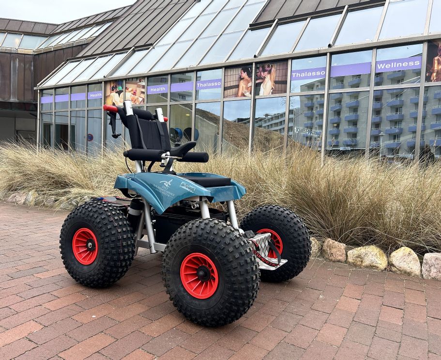 Elektrischer Strandrollstuhl für den Westerländer Strand steht vor dem Syltness Center