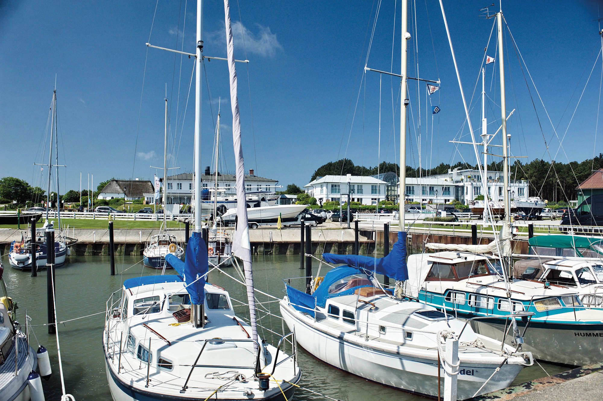 Segelboote im Hafen Munkmarsch im Hintergrund das Fährhaus Sylt
