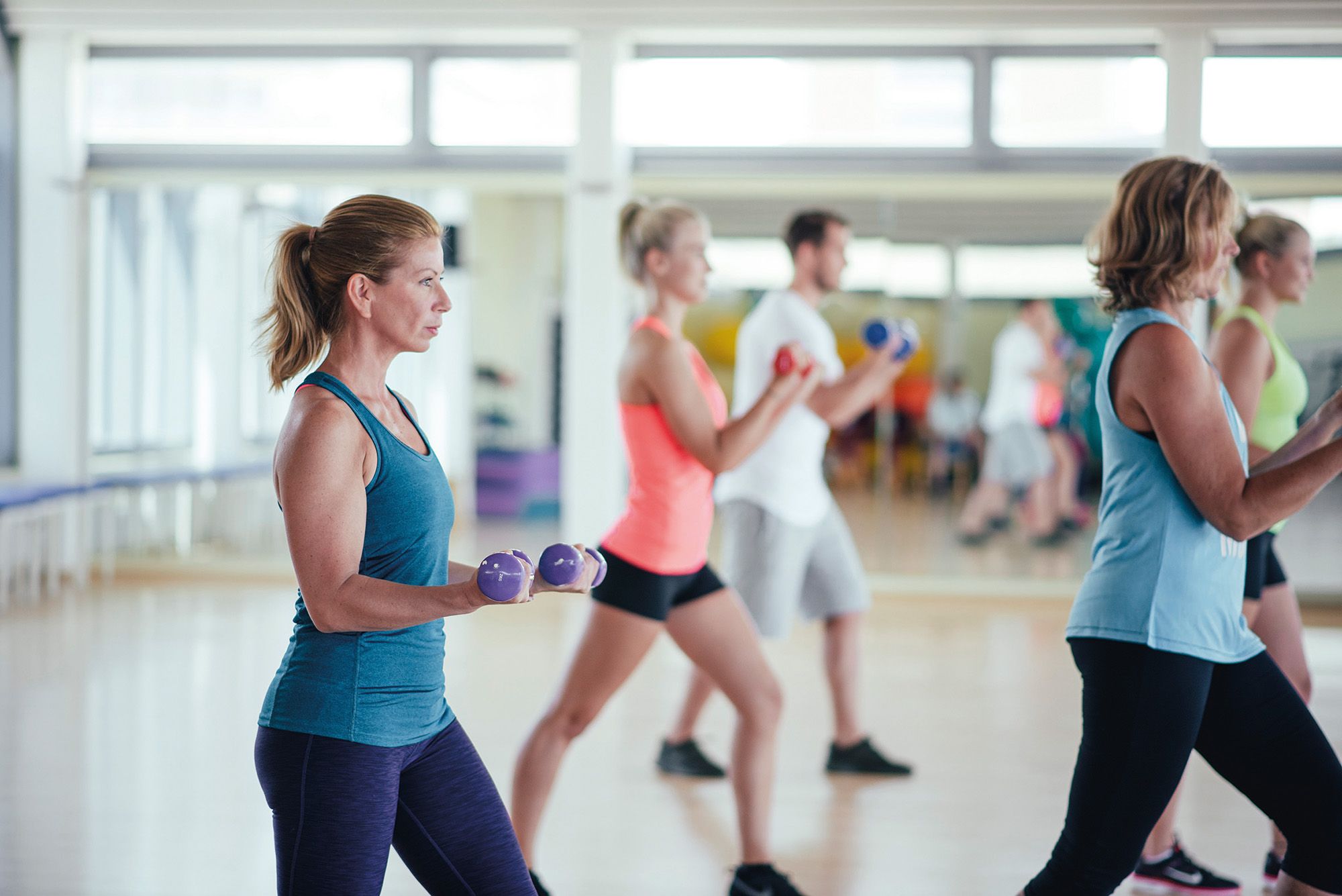 Frauen und Männer machen Sport mit kleinen Hanteln im Sportcenter in Westerland