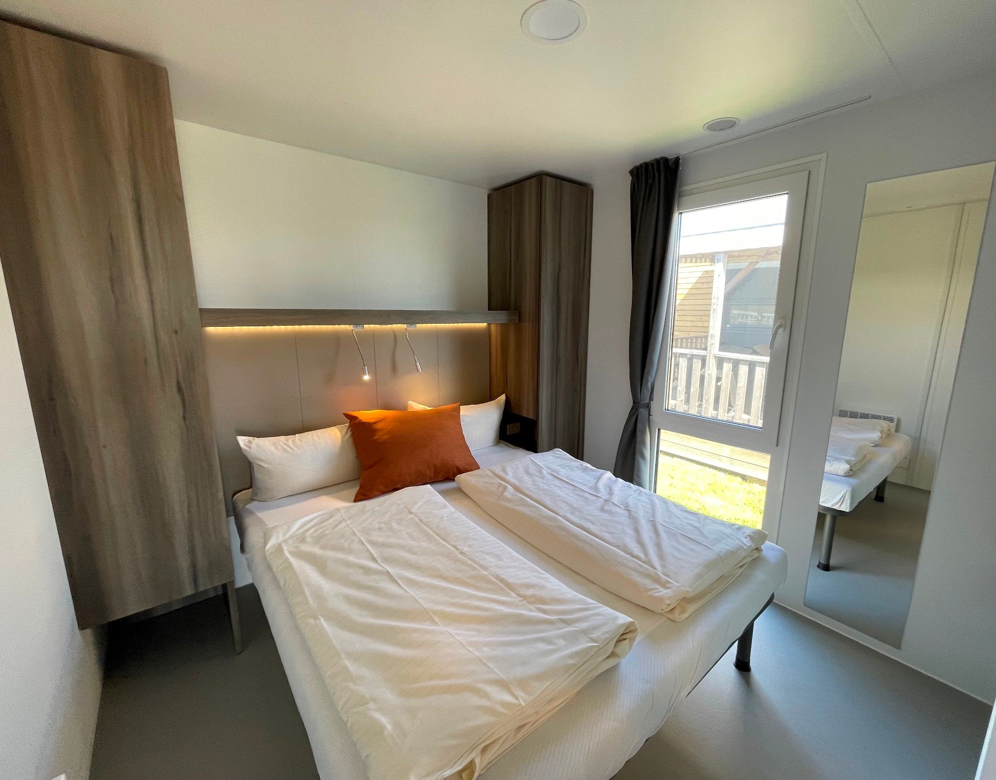 Schlafzimmer mit Doppelbett in einem großen Mobilheim auf dem Campingplatz Rantum auf Sylt