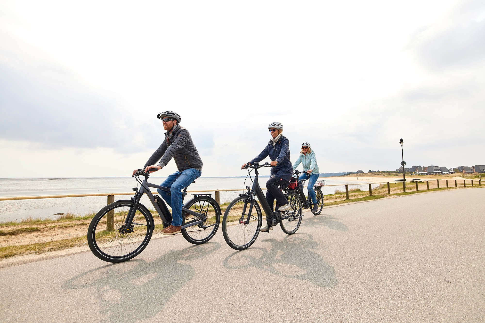 Eine Gruppe von drei Personen fährt mit den E-Bikes auf dem E-Mobility Center in Munkmarsch