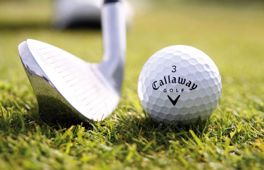 Golfball und Golfschläger in der Nahaufnahme auf dem Green eines Golfplatzes auf Sylt
