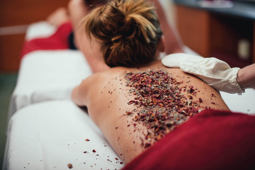 Frau mit Kräuterpackung auf dem Rücken erhält eine Massage im Syltness Center in Westerland auf Sylt
