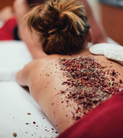 Frau mit Kräuterpackung auf dem Rücken erhält eine Massage im Syltness Center in Westerland auf Sylt