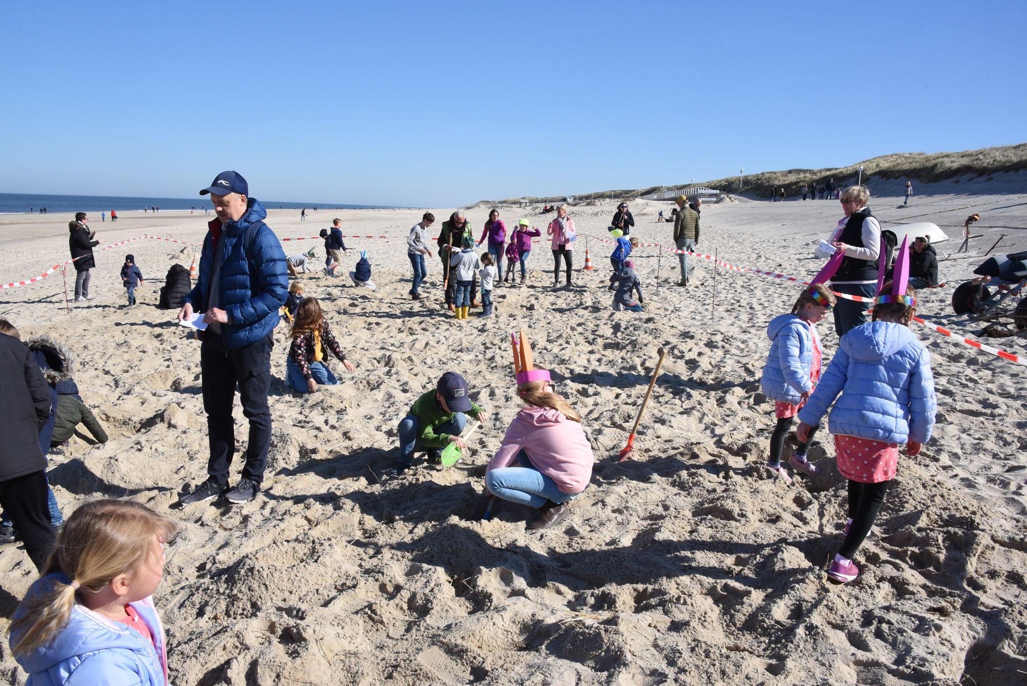 Kinder suchen nach versteckten Ostereien im Sand am Westerländer Strand
