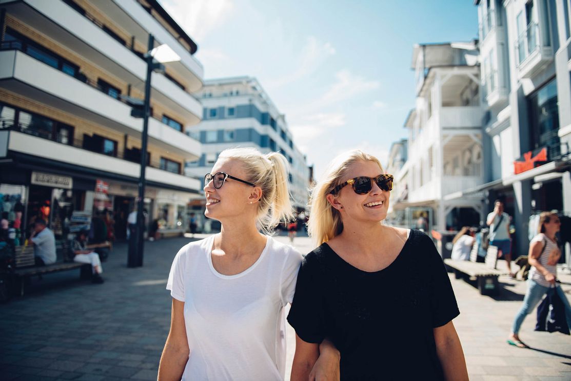 Zwei junge Frauen spazieren shoppend durch die Westerländer Friedrichstraße