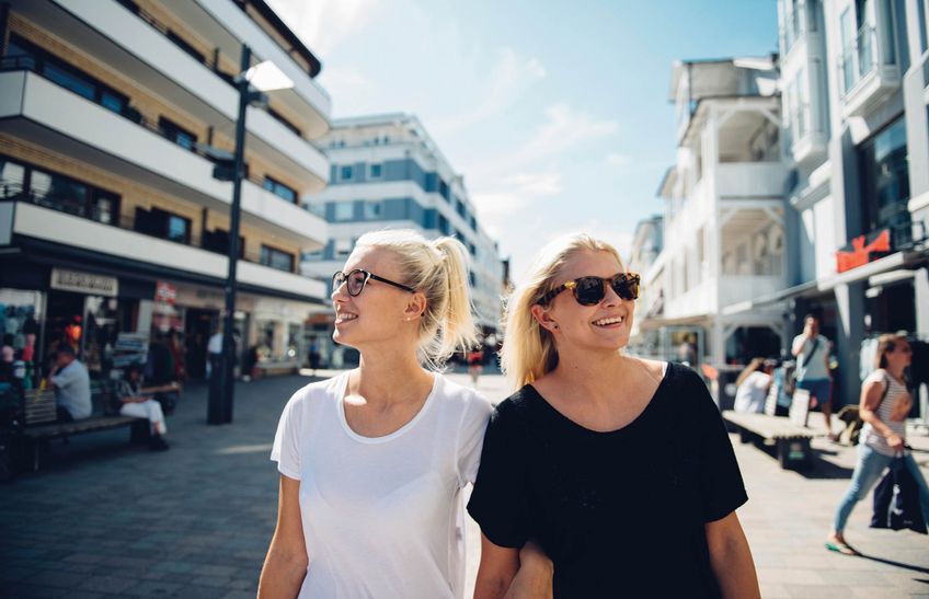 Zwei junge Frauen spazieren shoppend durch die Westerländer Friedrichstraße