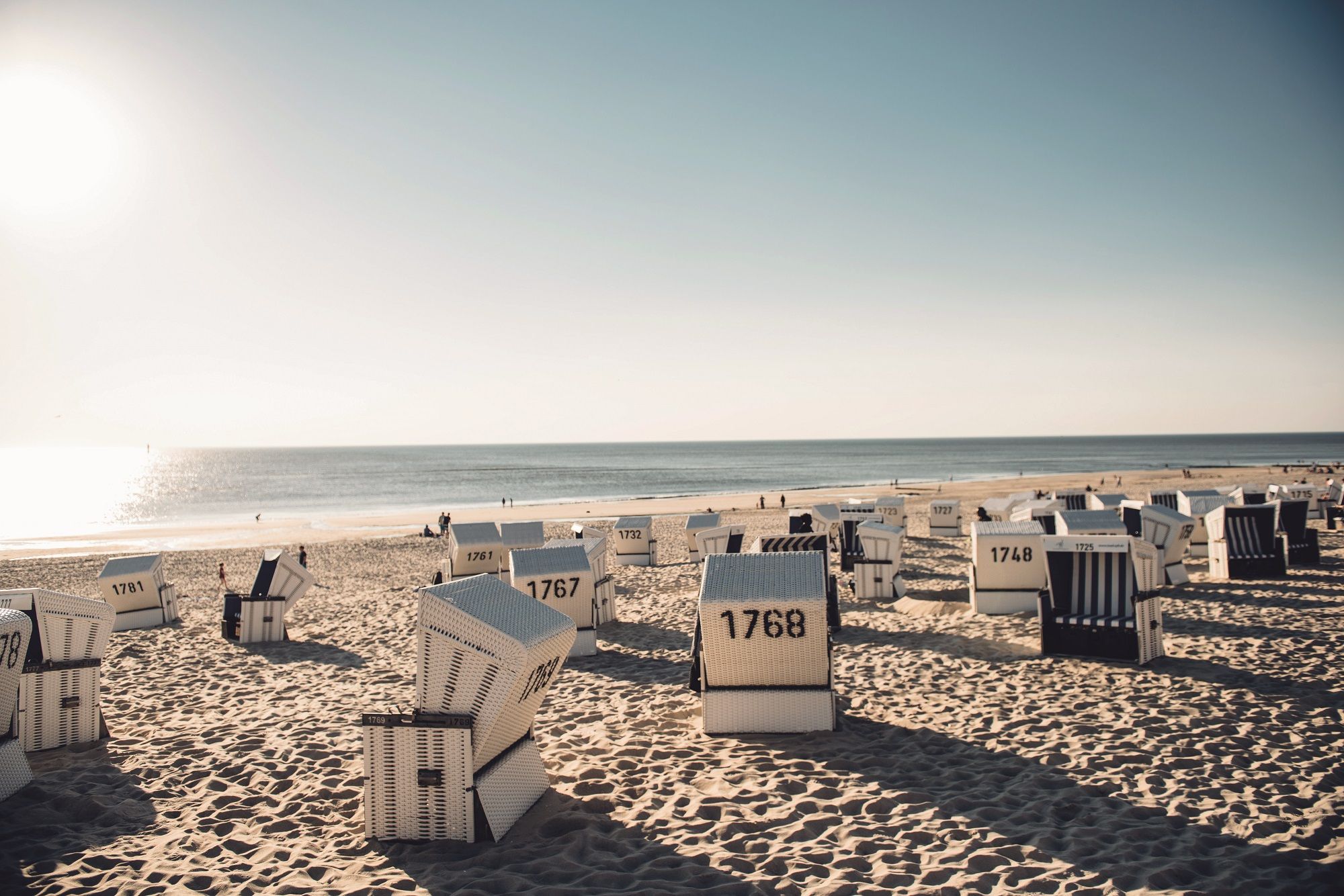 Strandkörbe am Strand von Westerland auf Sylt mit der ruhigen Nordsee im Hintergrund