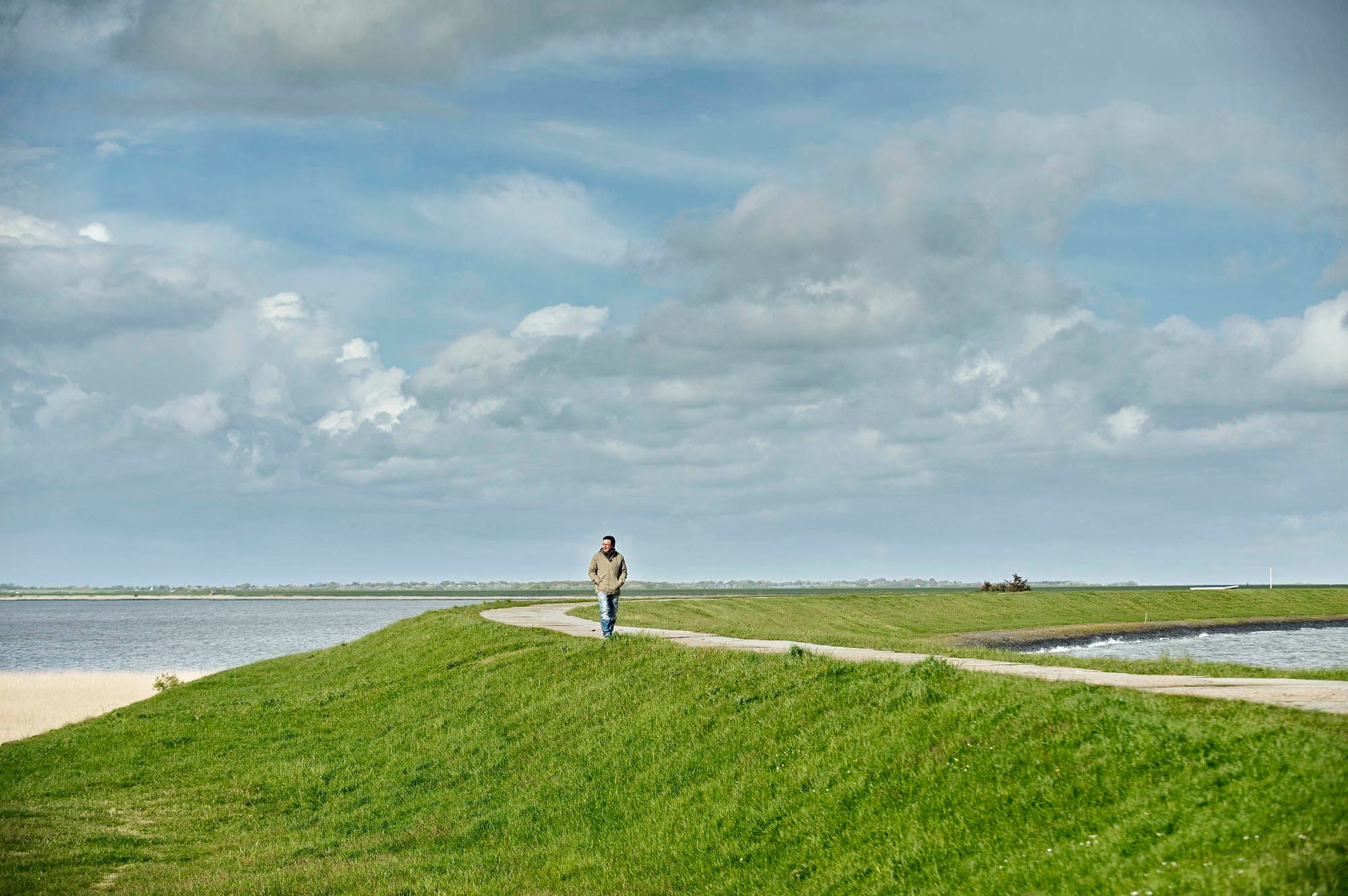 Mann spaziert auf dem Rantumbeckendeich