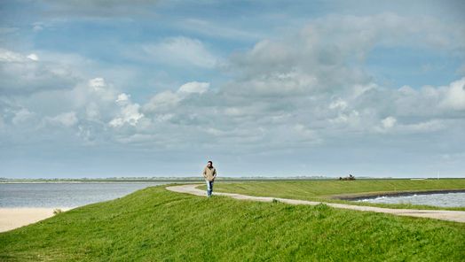 Mann spaziert auf dem Rantumbeckendeich