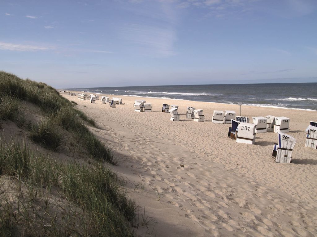 Sylter Weststrand mit Strandkörben und mit Dünengras bewachsener Düne