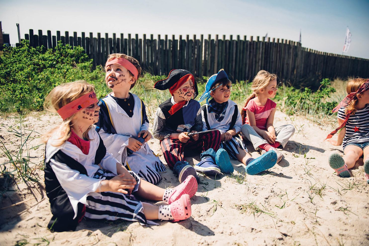 Mehrere Kinder sitzen kostümiert in einer Runde beim Piratentag der Villa Kunterbunt