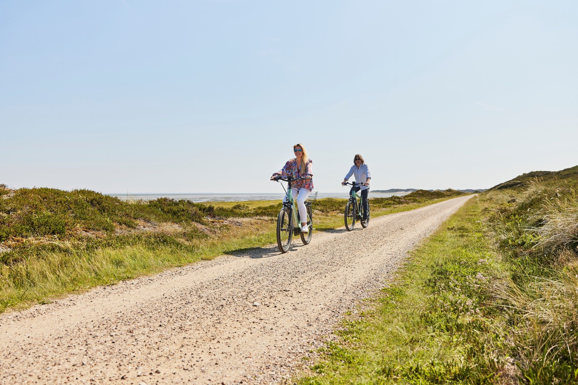 Eine Frau und ein Mann machen eine Fahrradtour in Rantum mit den E-Bikes aus dem E-Mobility Center