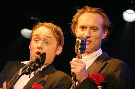 die beiden Mitglieder von Bidla Buh im Frack mit Mikrofon und Gitarre in der Hand