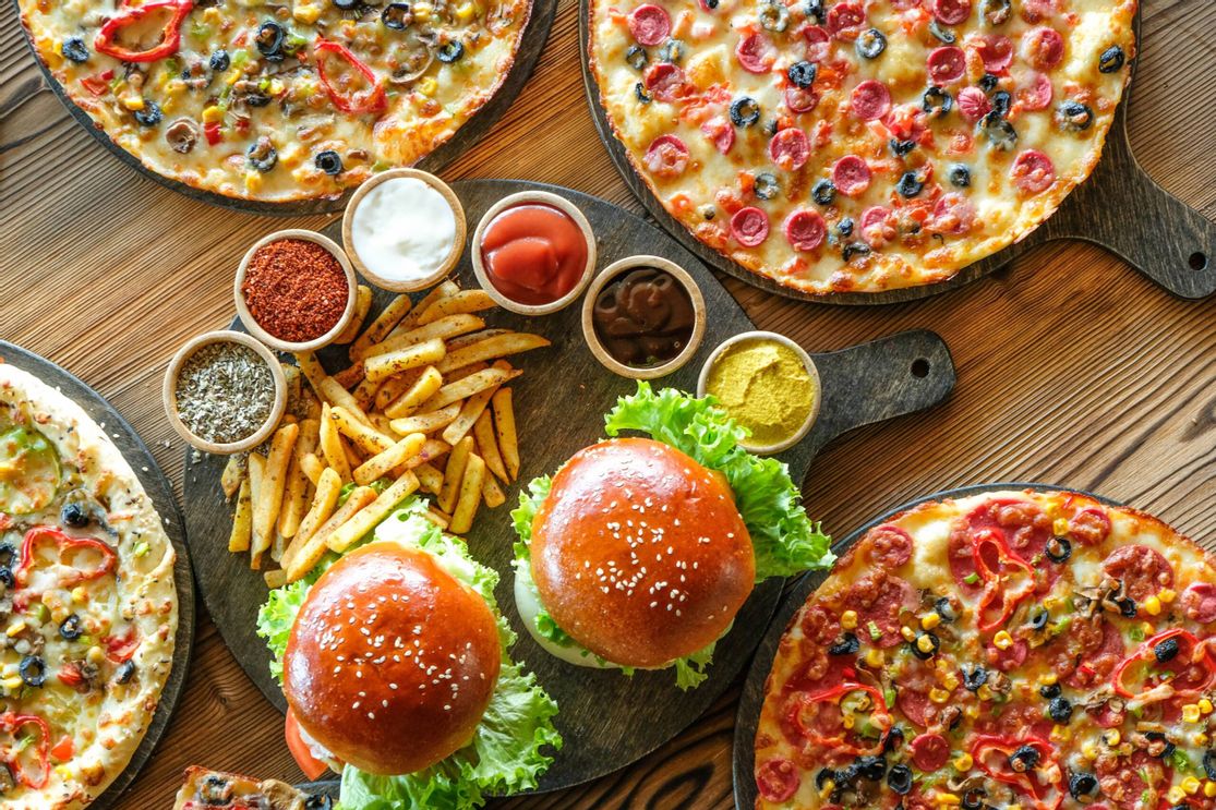 Tisch mit Pizzen, Burger und Pommes mit Dips Mikado Sylt