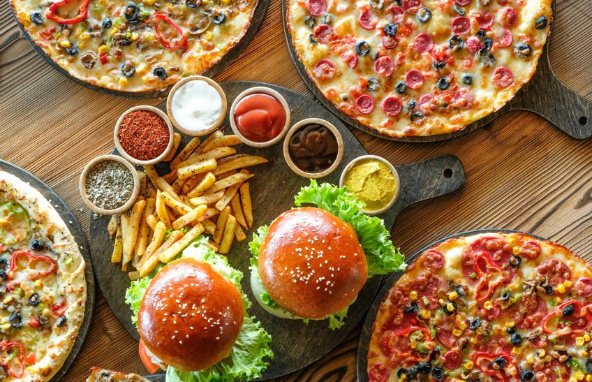 Tisch mit Pizzen, Burger und Pommes mit Dips Mikado Sylt